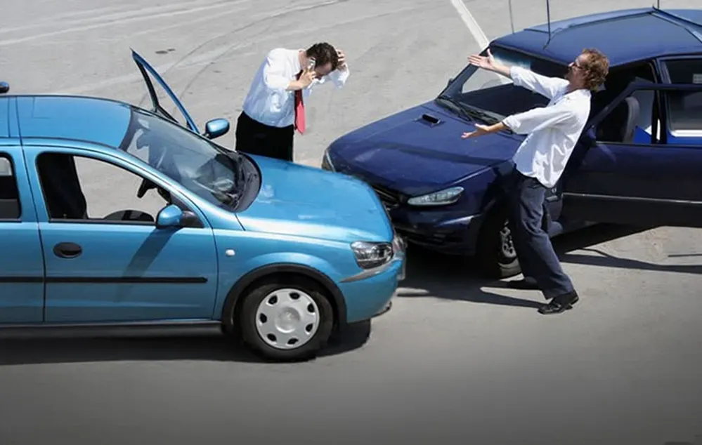 Două mașini după o coliziune și două persoane gesticulând lângă vehiculele avariate