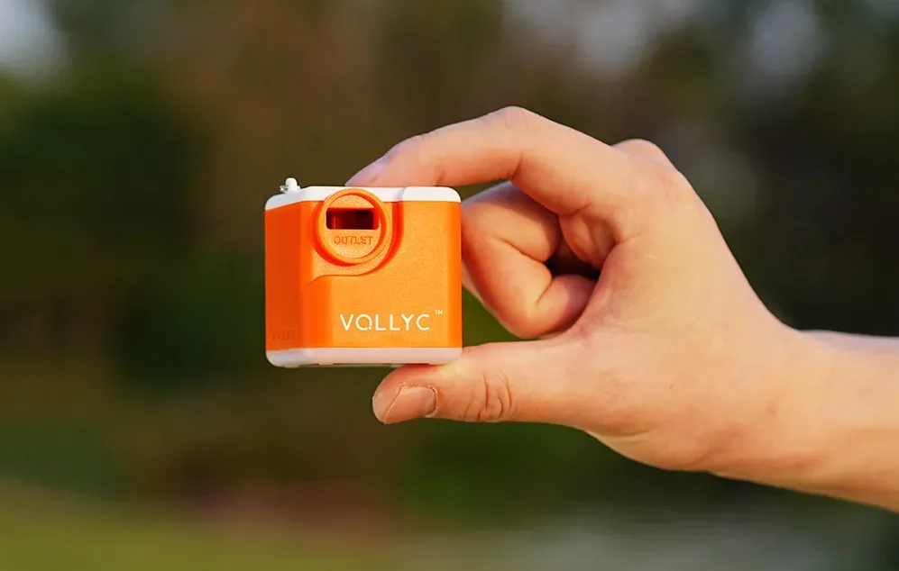 Pompa Nano ținută între degete, arătând dimensiunea sa compactă și ieșirea